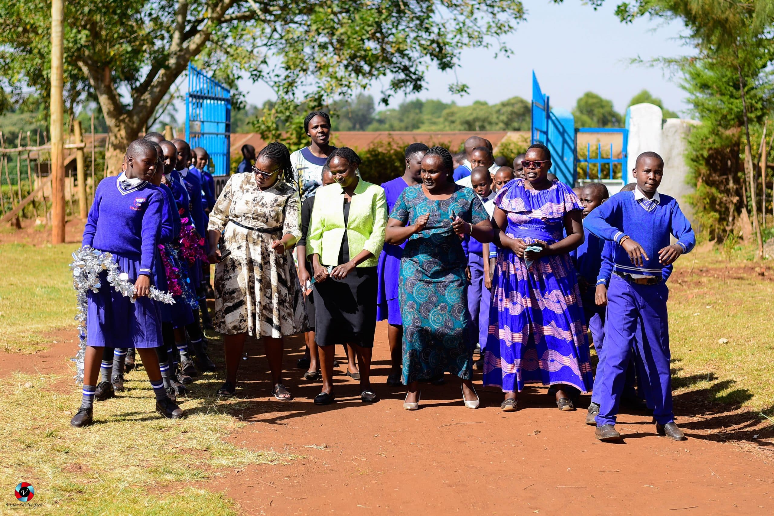 Female teachers and students dancing together during a school welcome