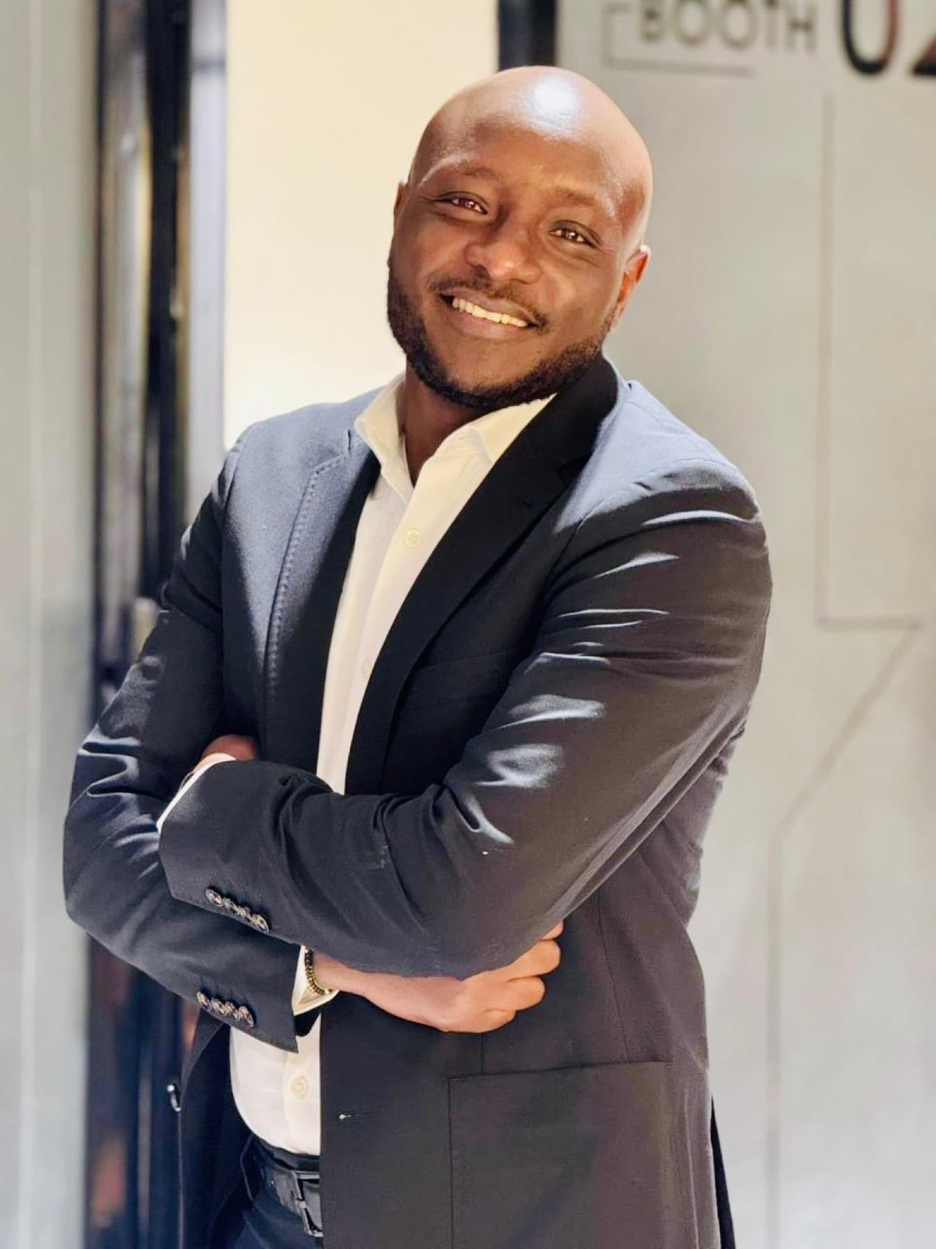 Peter Rotich standing in a dark suit and smiling