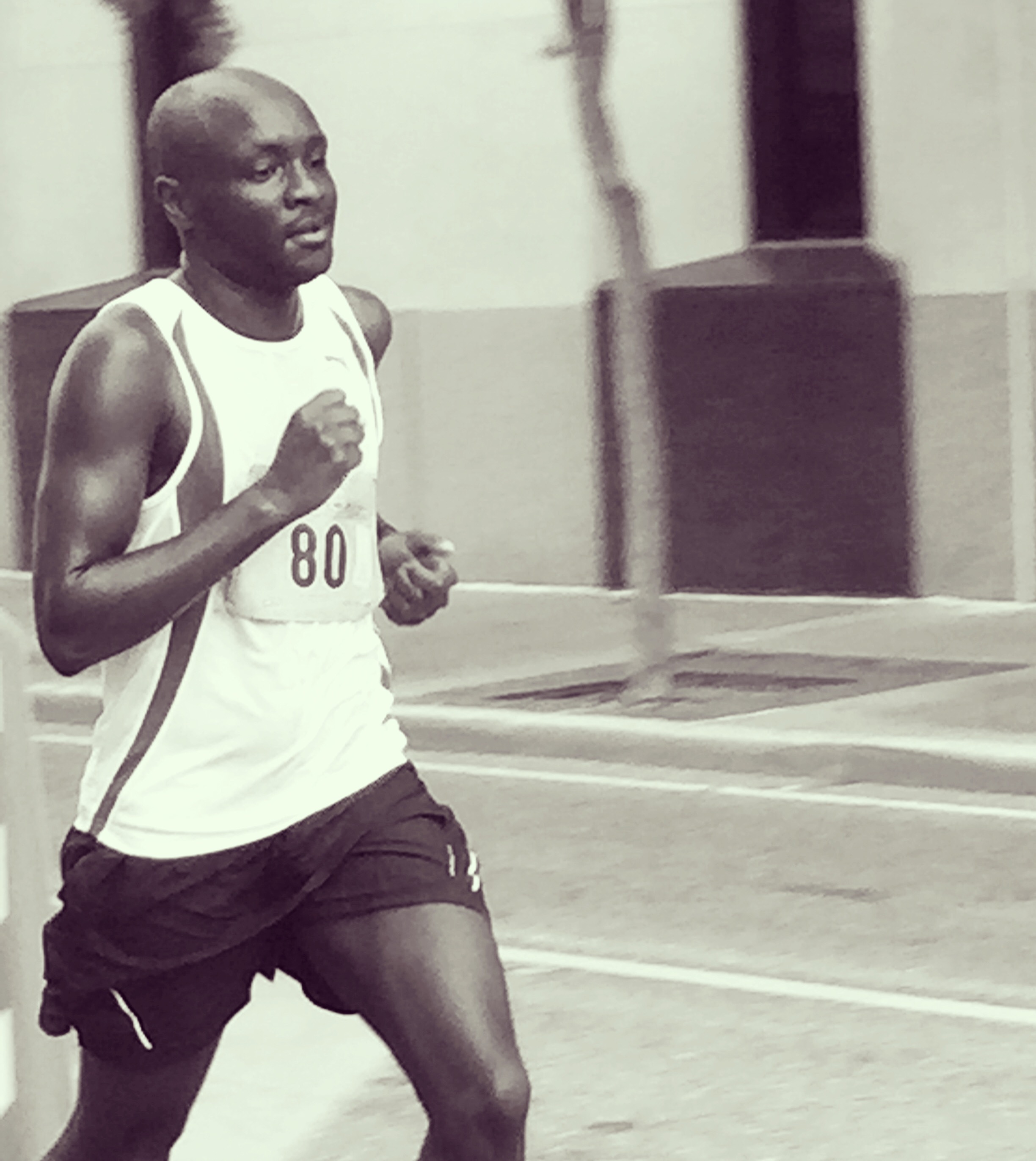 Peter Rotich running after college in a white race singlet
